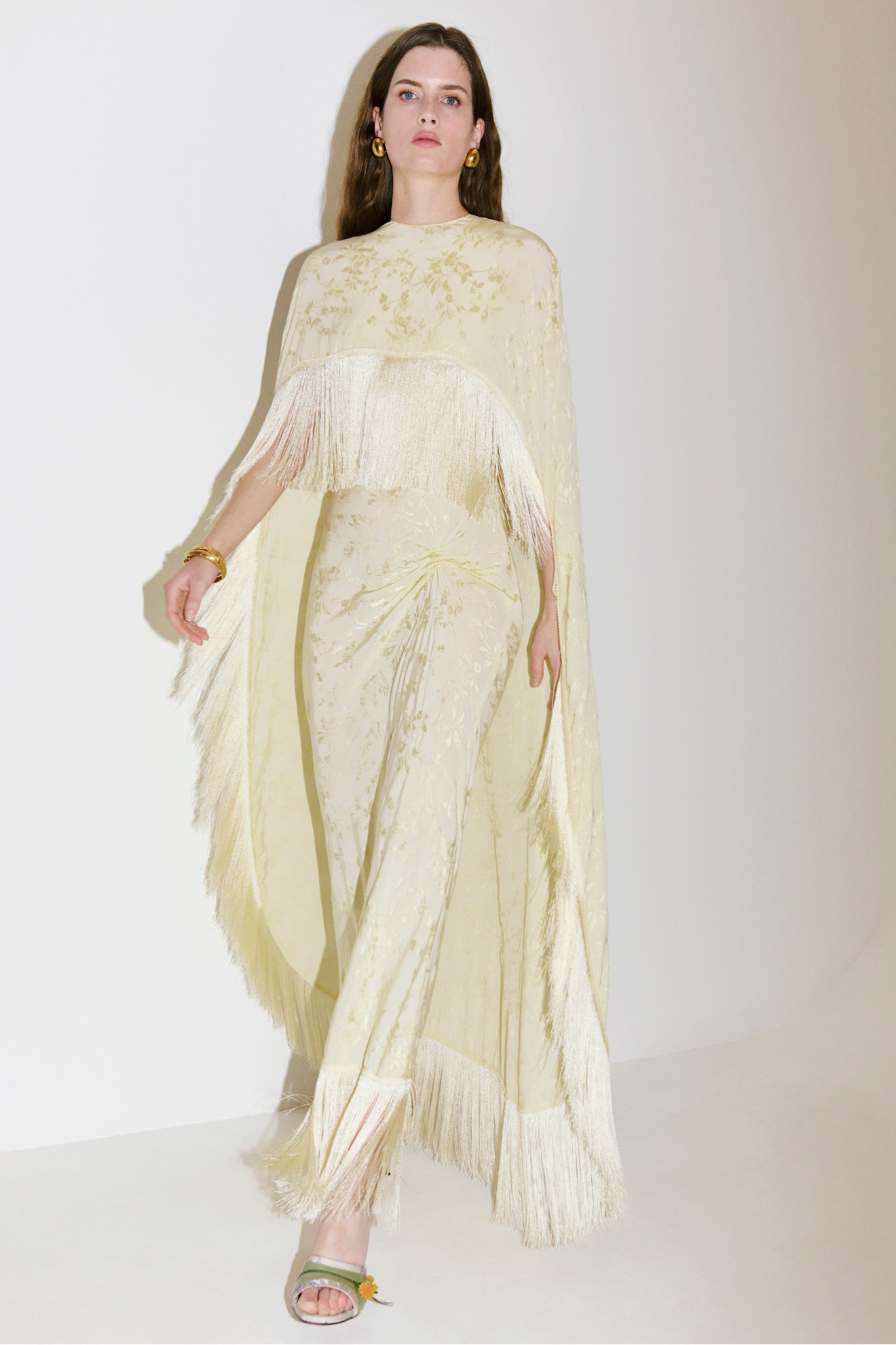 A model wearing a cape fringe dress from Anna October's pre-fall 2026 collection.