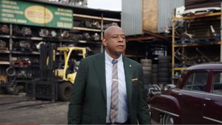 Forest Whitaker as Bumpy Johnson walking by cars in Godfather of Harlem season 3