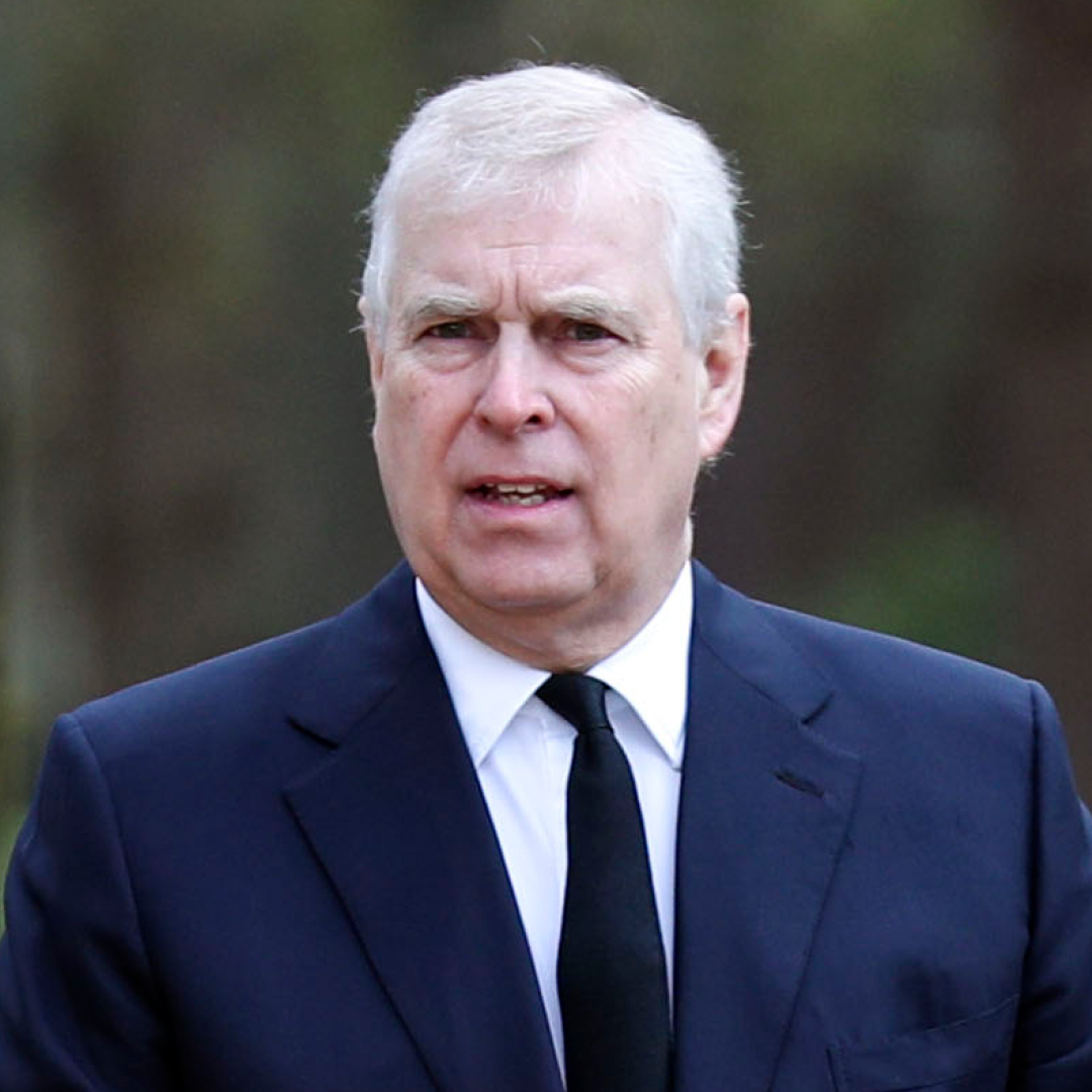 Prince Andrew wears a suit and looks bemused