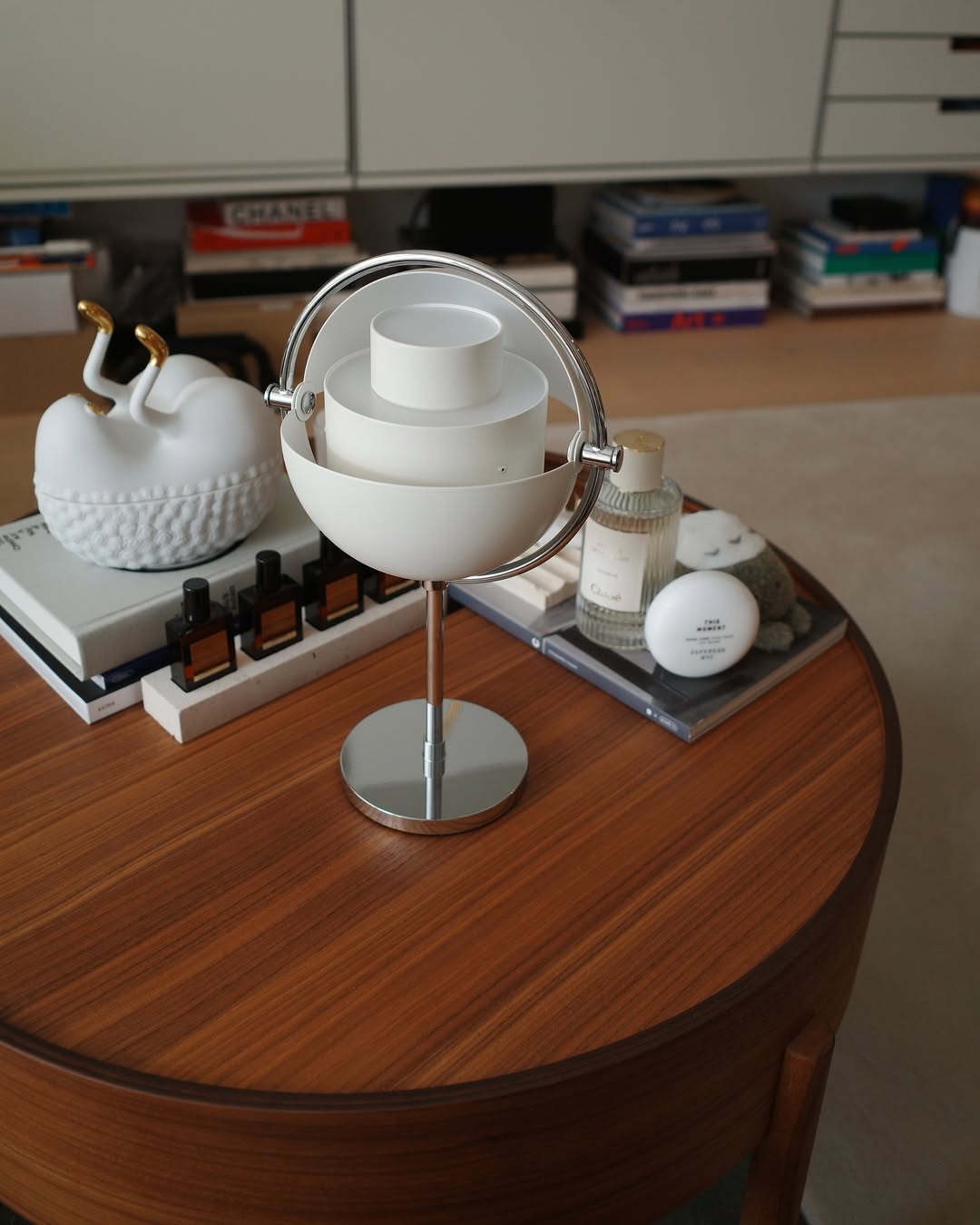 The Multi-Lite by Gubi in White Semi Matt and beauty products on a wooden table