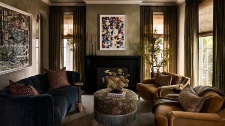 moody olive green living room with fringed ottoman and velvet sofas