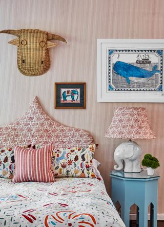 Kid's bedroom with patterned headboard, pillows and wallpaper