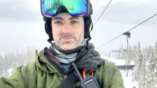 A photo of writer Dan Bracaglia in snowboard gear riding a ski lift