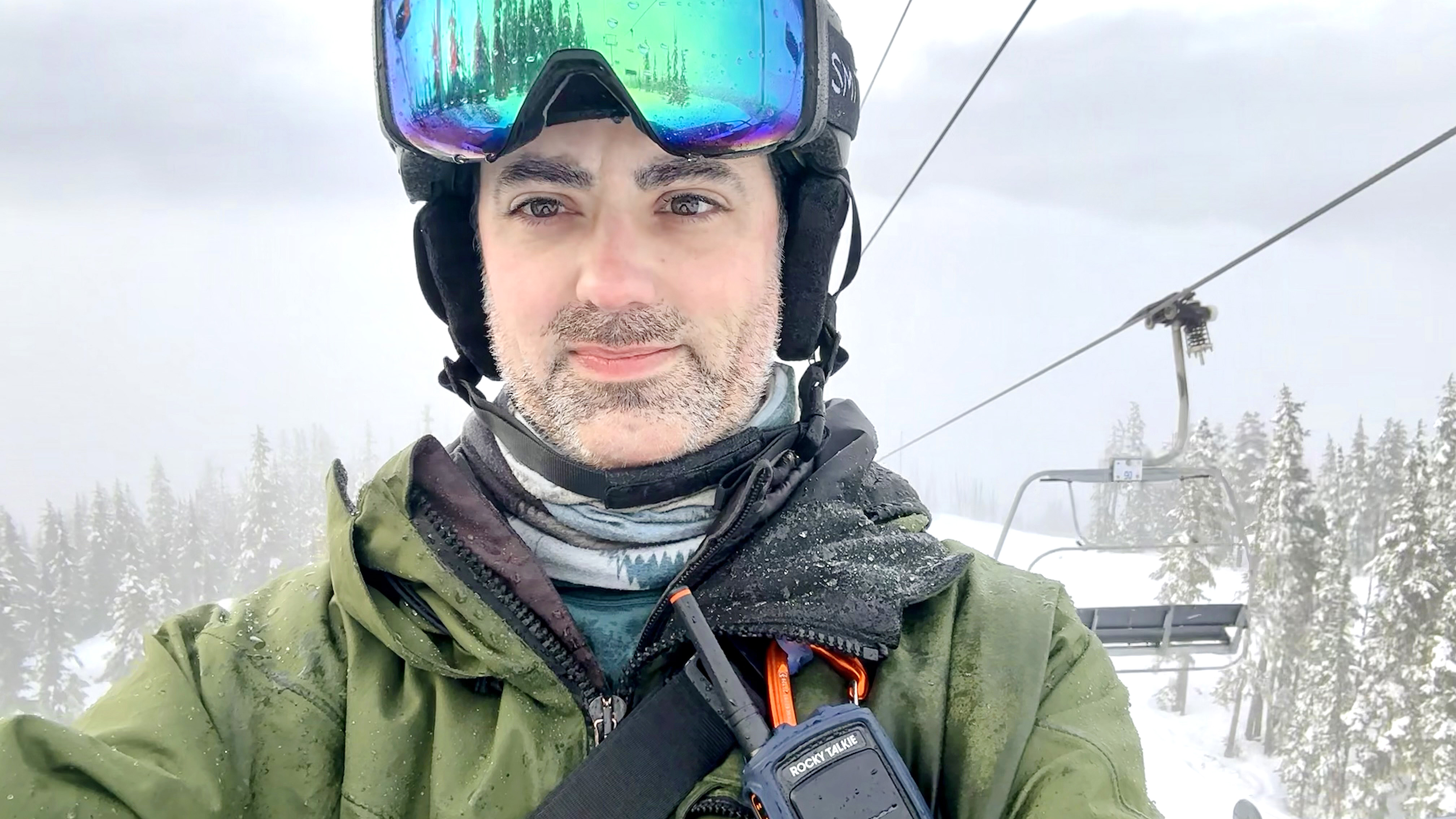 A photo of writer Dan Bracaglia in snowboard gear riding a ski lift