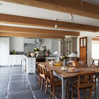 kitchen with wooden dining set and stone flooring
