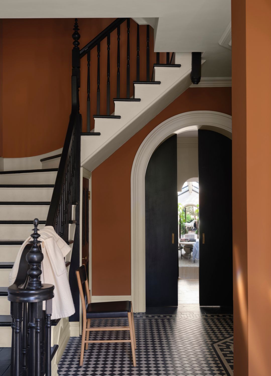 picture of dark orange hallway with black and white staircase