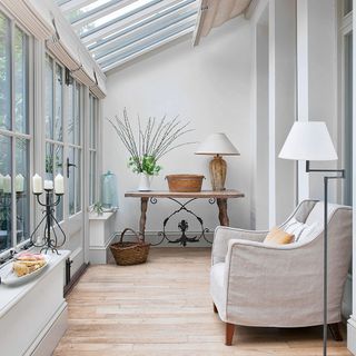 conservatory with white wall and white lamp and arm chair and wooden floor