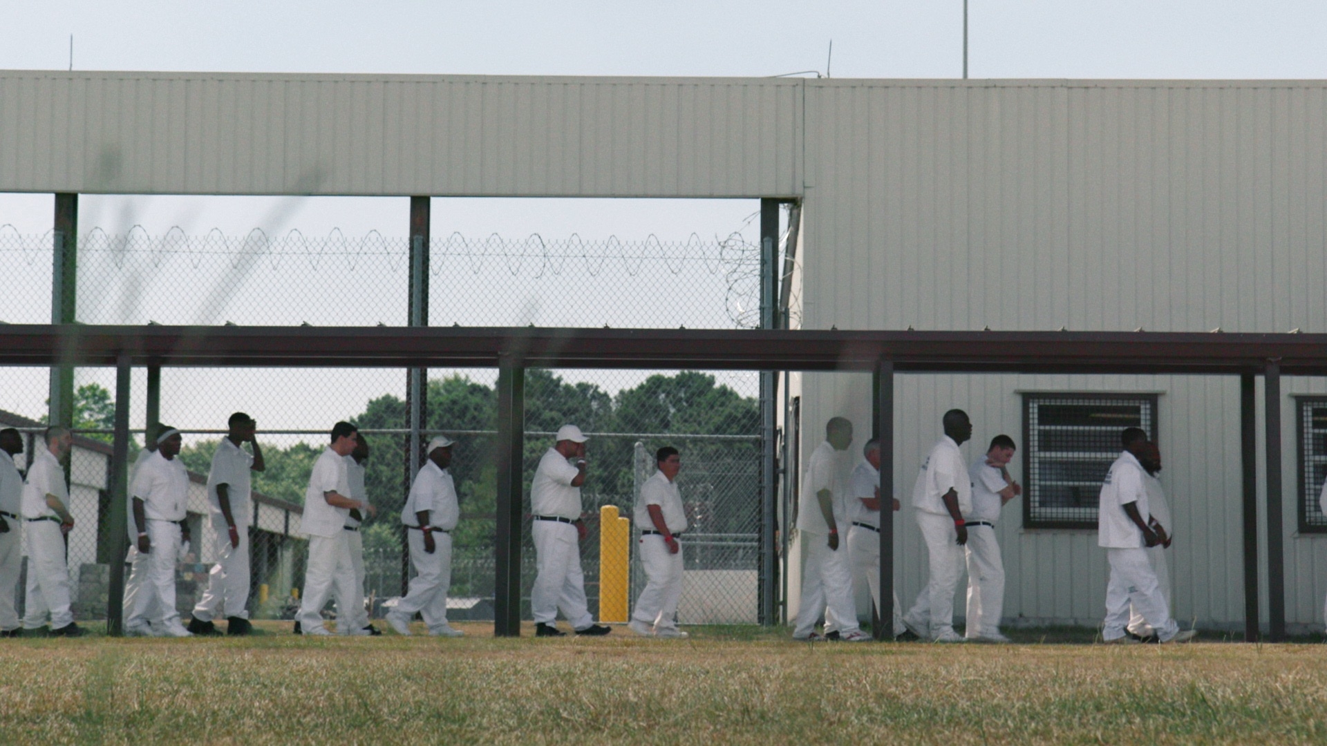 Incarcerated men walk through a prison complex, in a still from HBO's 'The Alabama Solution.'