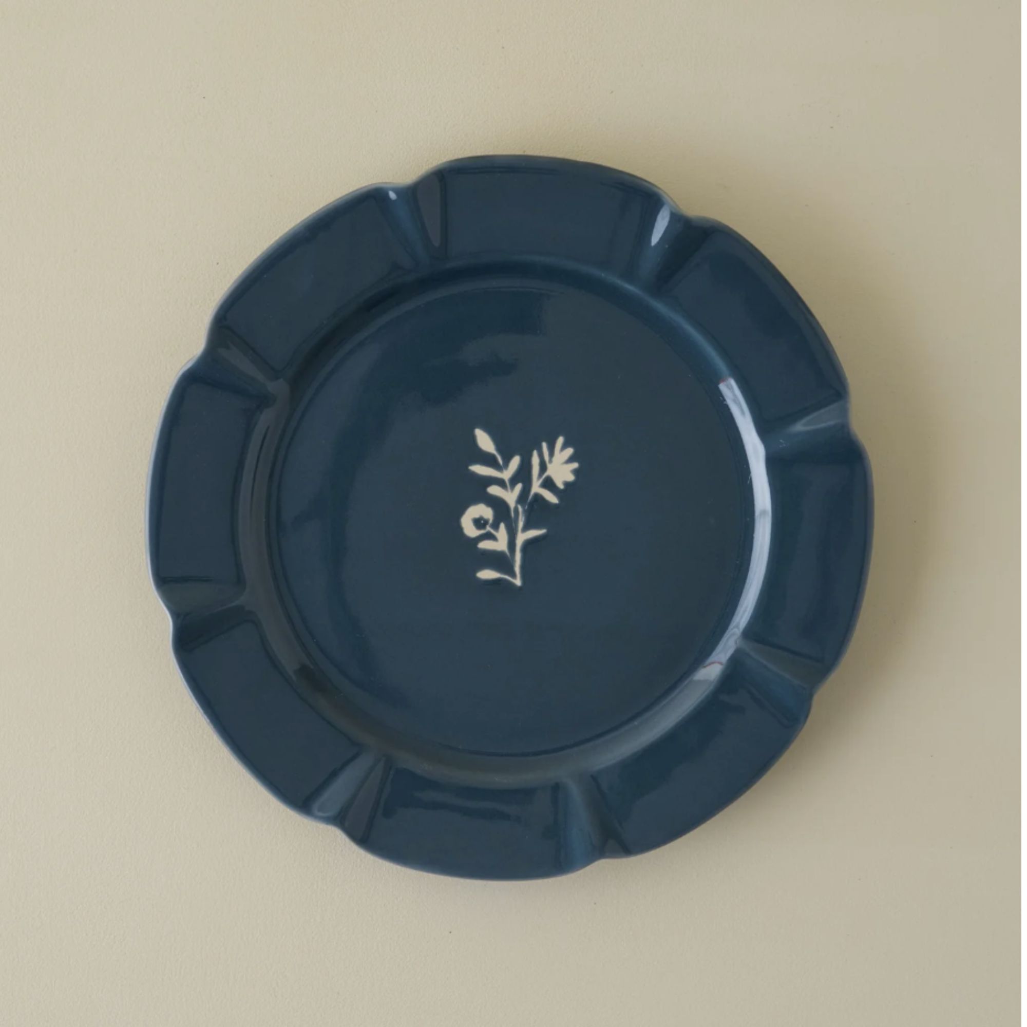 Midnight blue plate with carved edge and white floral motif