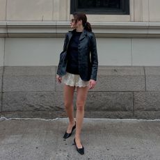 Eliza Huber wearing a leather blazer, lace shorts, and flats.