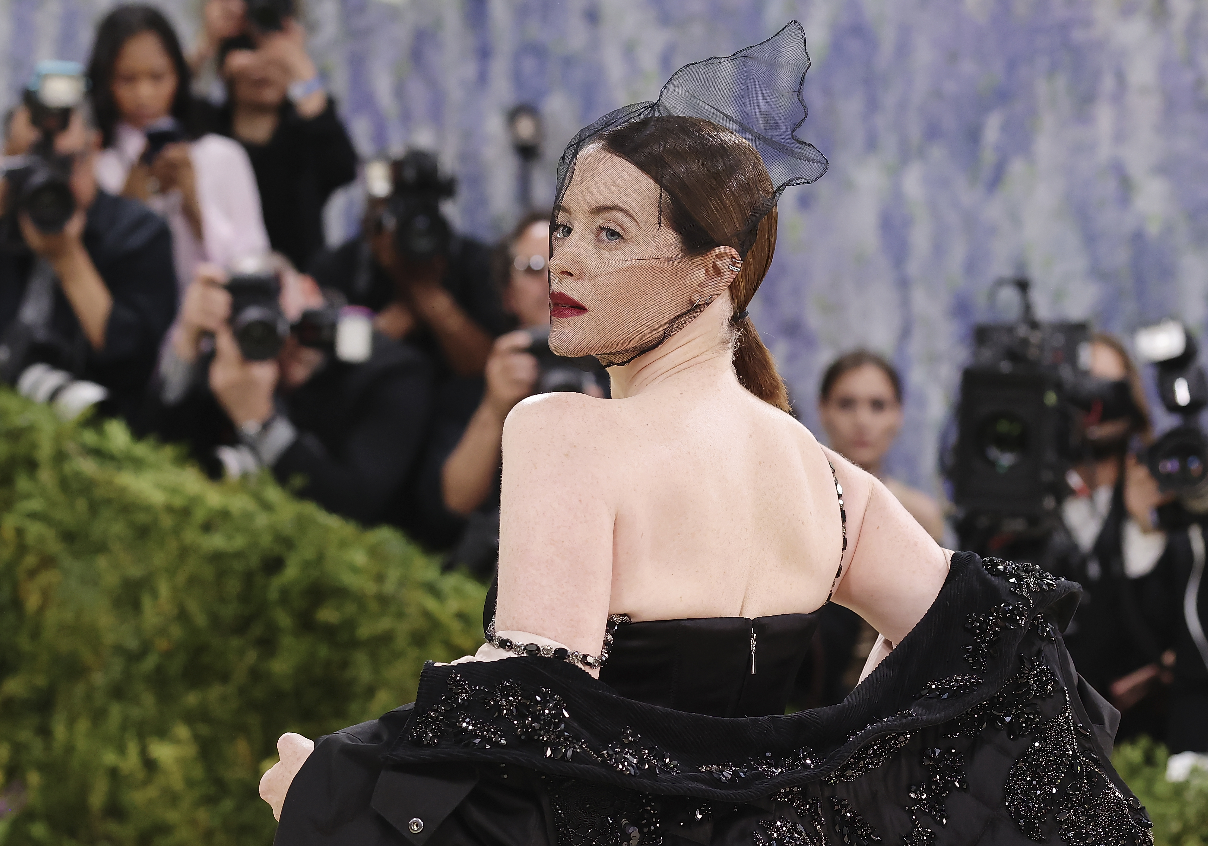 a woman in a black cape with a sheer black headress