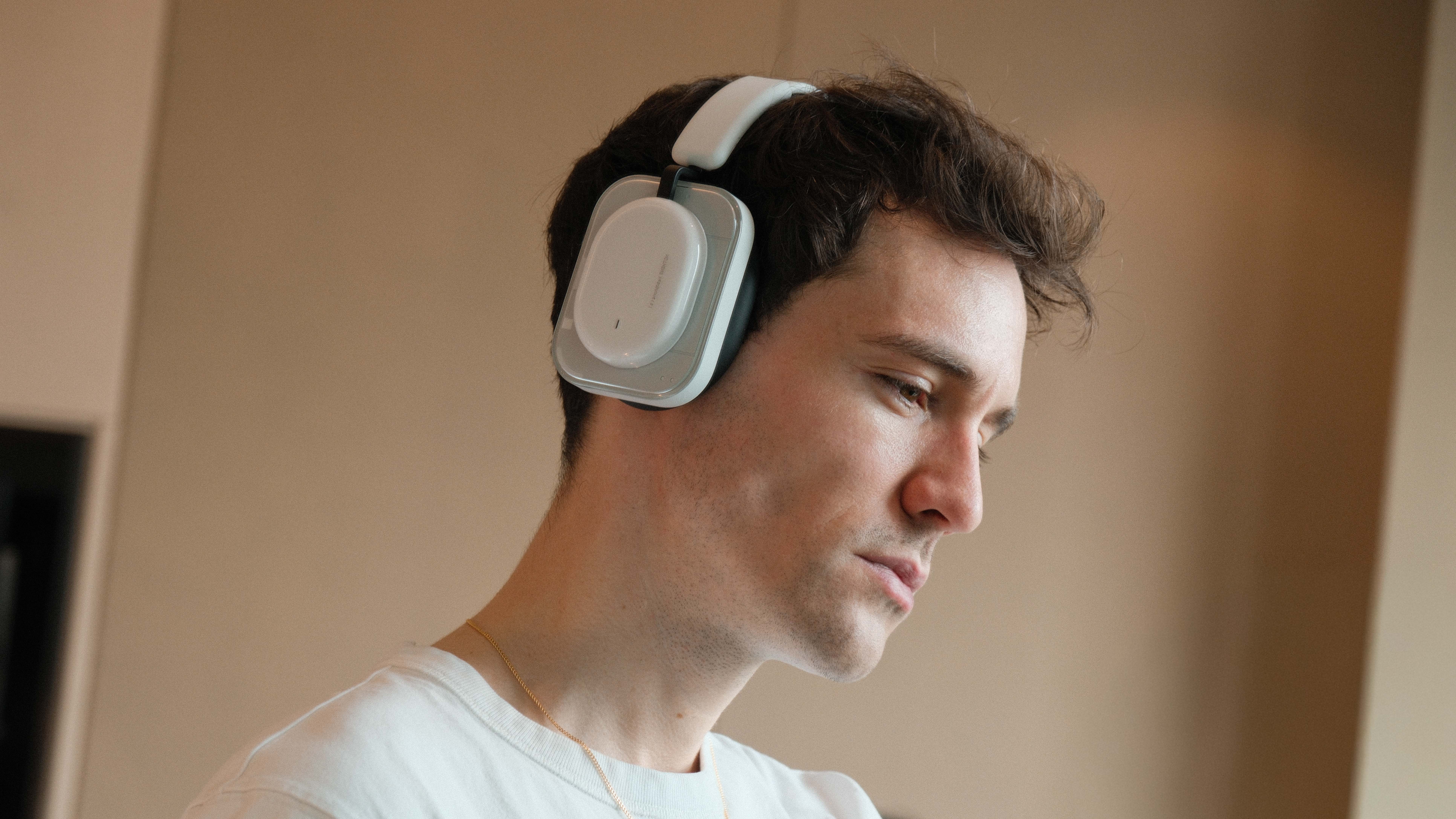 Person wearing white Nothing Headphones (a) in profile