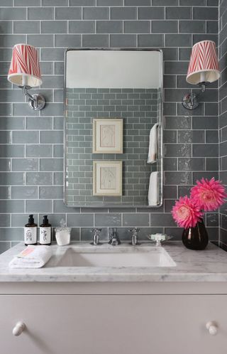 Tiled grey bathroom with marble sink and pink accents