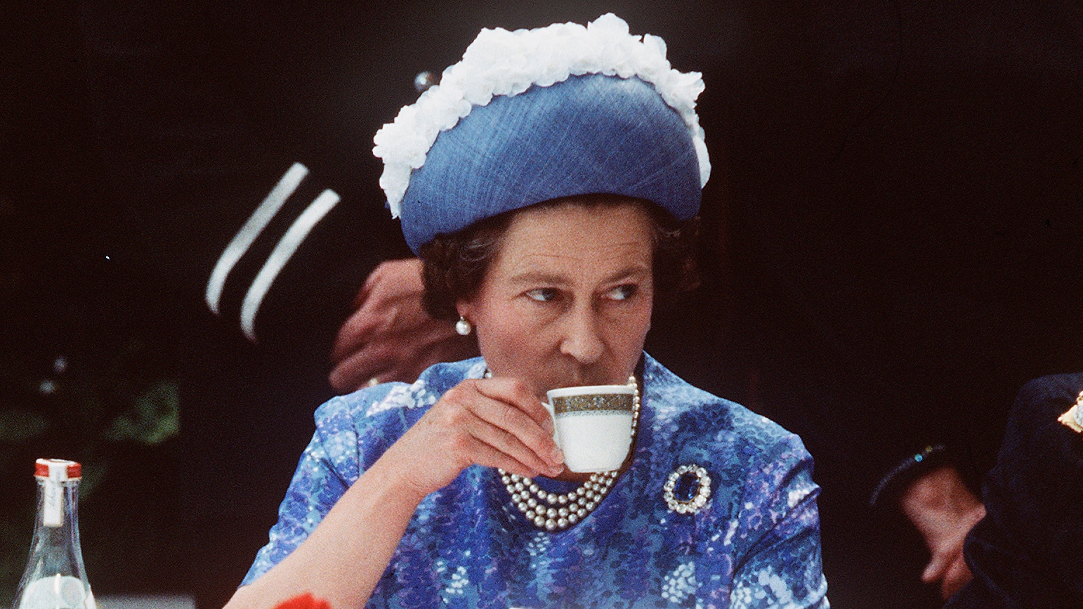 Queen Elizabeth drinks a cup of tea while in Northern Ireland on a royal visit in 1977