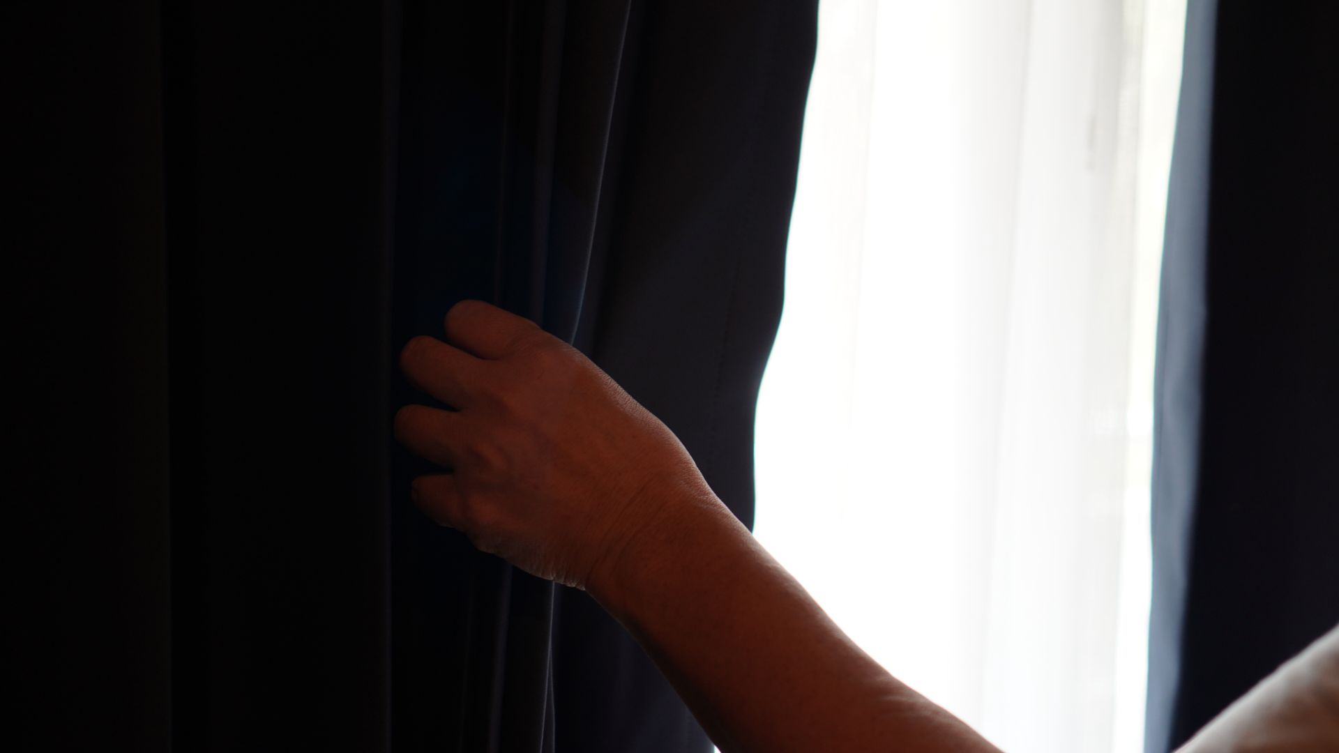 picture of person closing black-out curtains