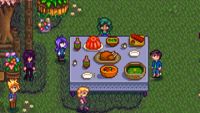 Stardew Valley - The player farmer standing at the Flower Dance festival's big dining table, near Shane, Abigail, Pam, and Sebastian