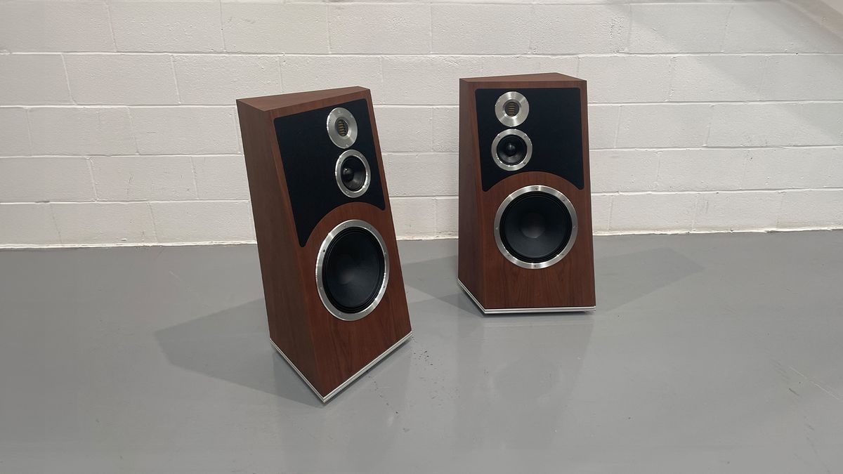 Audiovector Trapeze Reimagined floorstanding speakers on grey floor against white brick wall