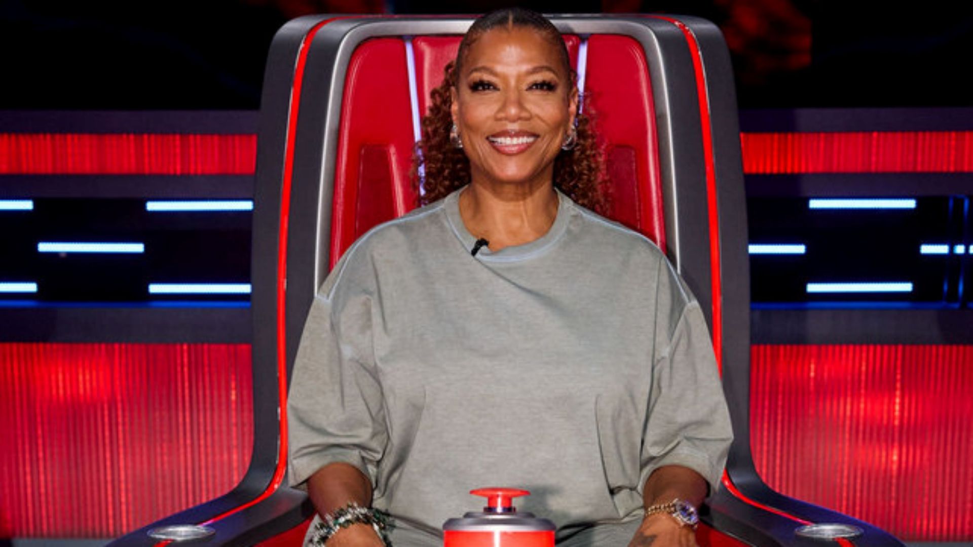 The Voice coach Queen Latifah sitting in her big red chair on Season 30.
