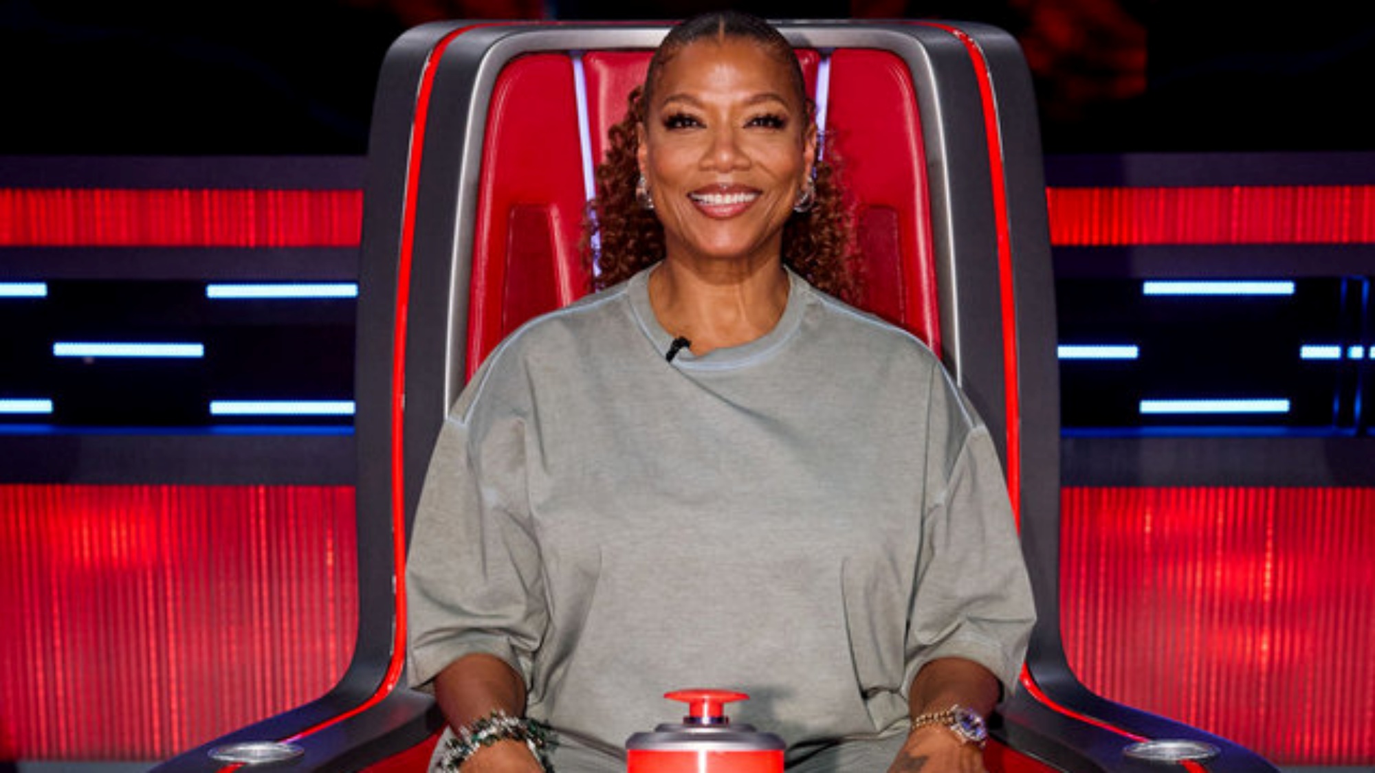 The Voice coach Queen Latifah sitting in her big red chair on Season 30.