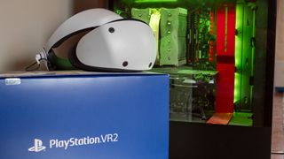 A PSVR 2 headset on top of its box next to a PC