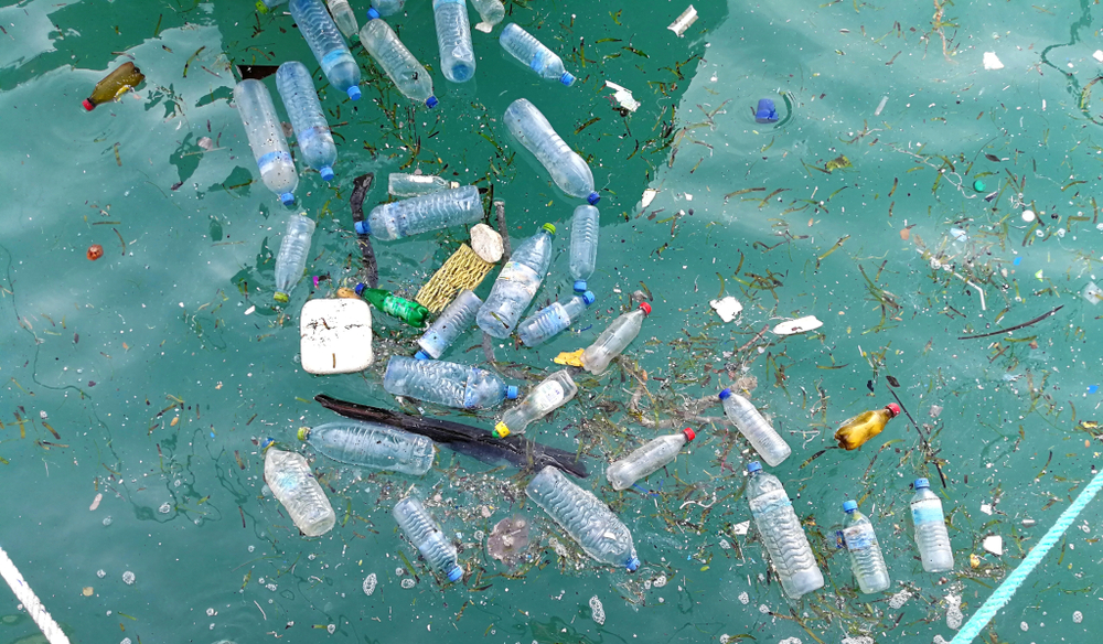 A photograph of plastic trash and water bottles floating in the ocean