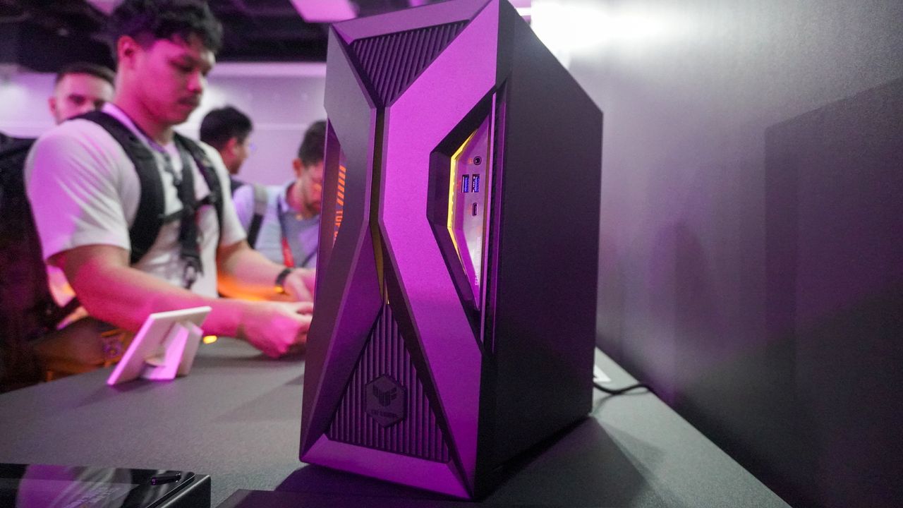 Asus TUF Gaming T500 gaming PC on table with people in the background