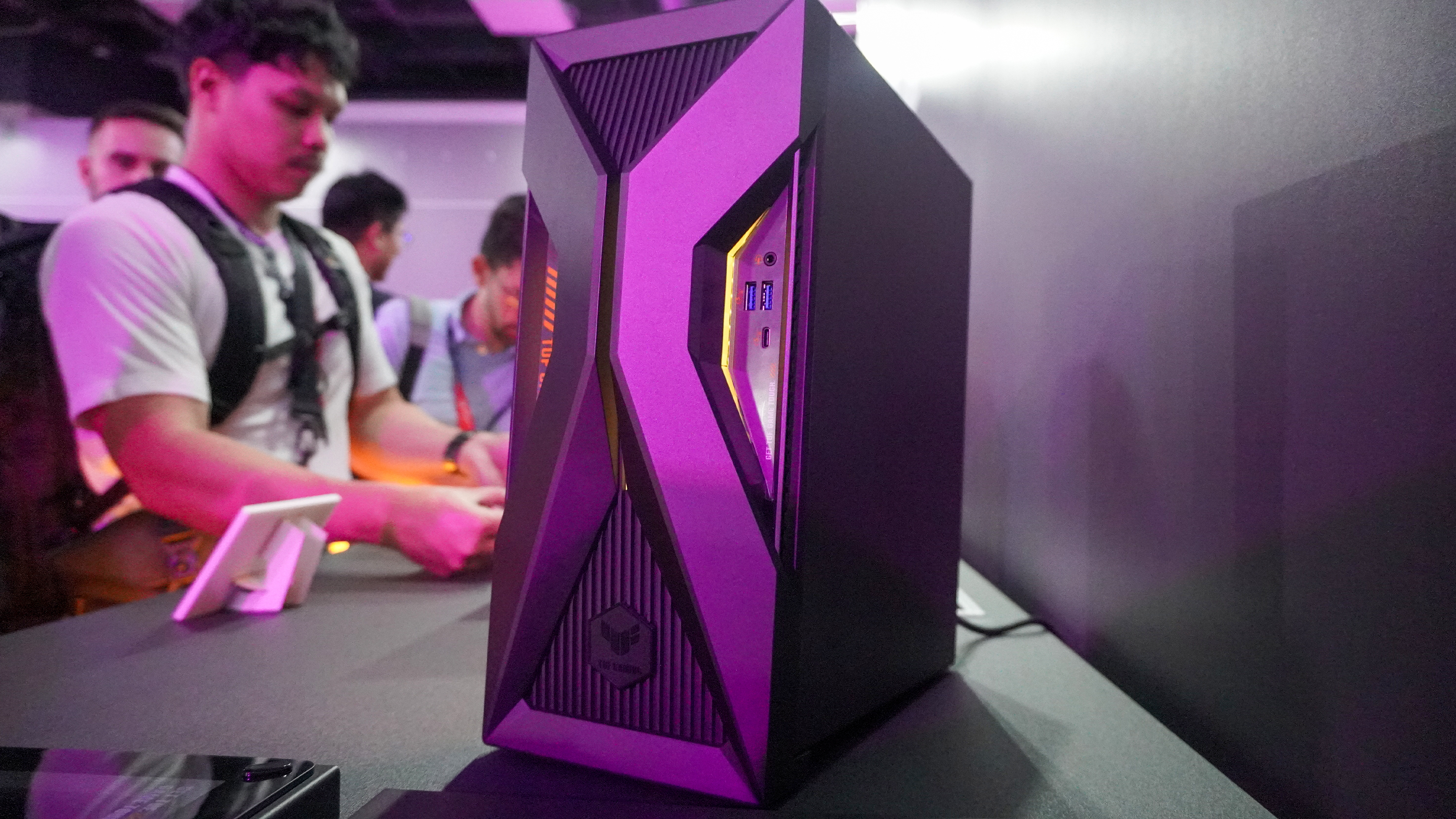 Asus TUF Gaming T500 gaming PC on table with people in the background