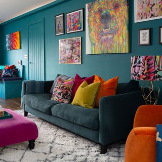 Teal living room with sofa, pink ottoman, rug and gallery wall