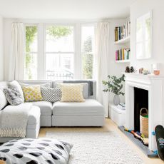 White living room with fireplace, L-shaped sofa and bean bag