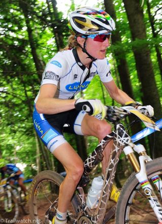 Catharine Pendrel (Luna Pro Team) climbing in the woods 50 seconds behind Gould