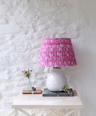 pink and white pleated lampshade on white table lamp