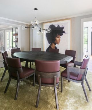 A dining room with black dining table and burgundy leather dining chairs