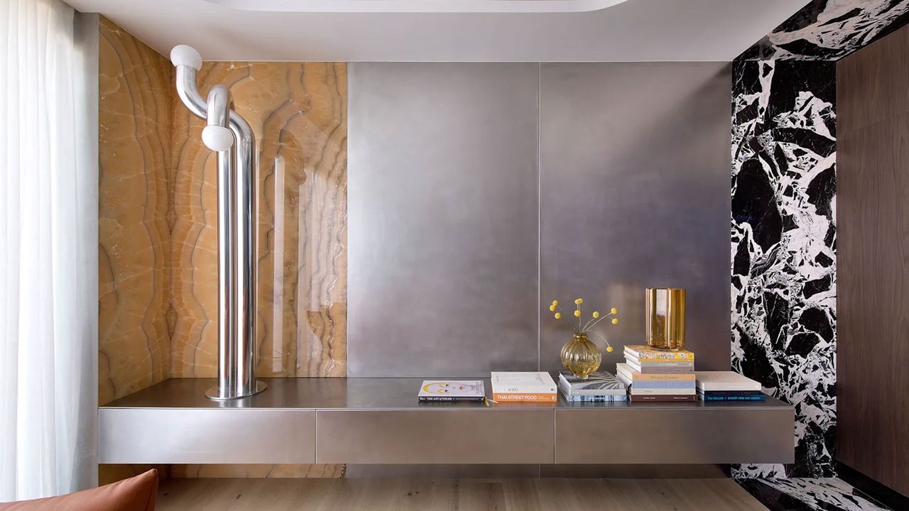 a floating cabinet in a modern living room made from stainless steel and two types of stone