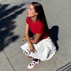 Helena wears white skirt, red tee, and pink adidas.