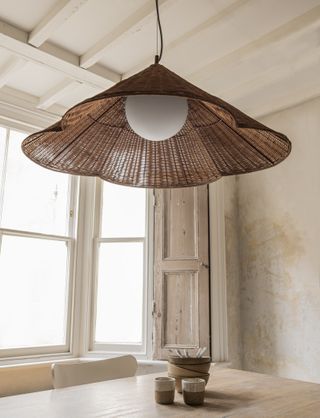 A cane lighting piece above the dining table