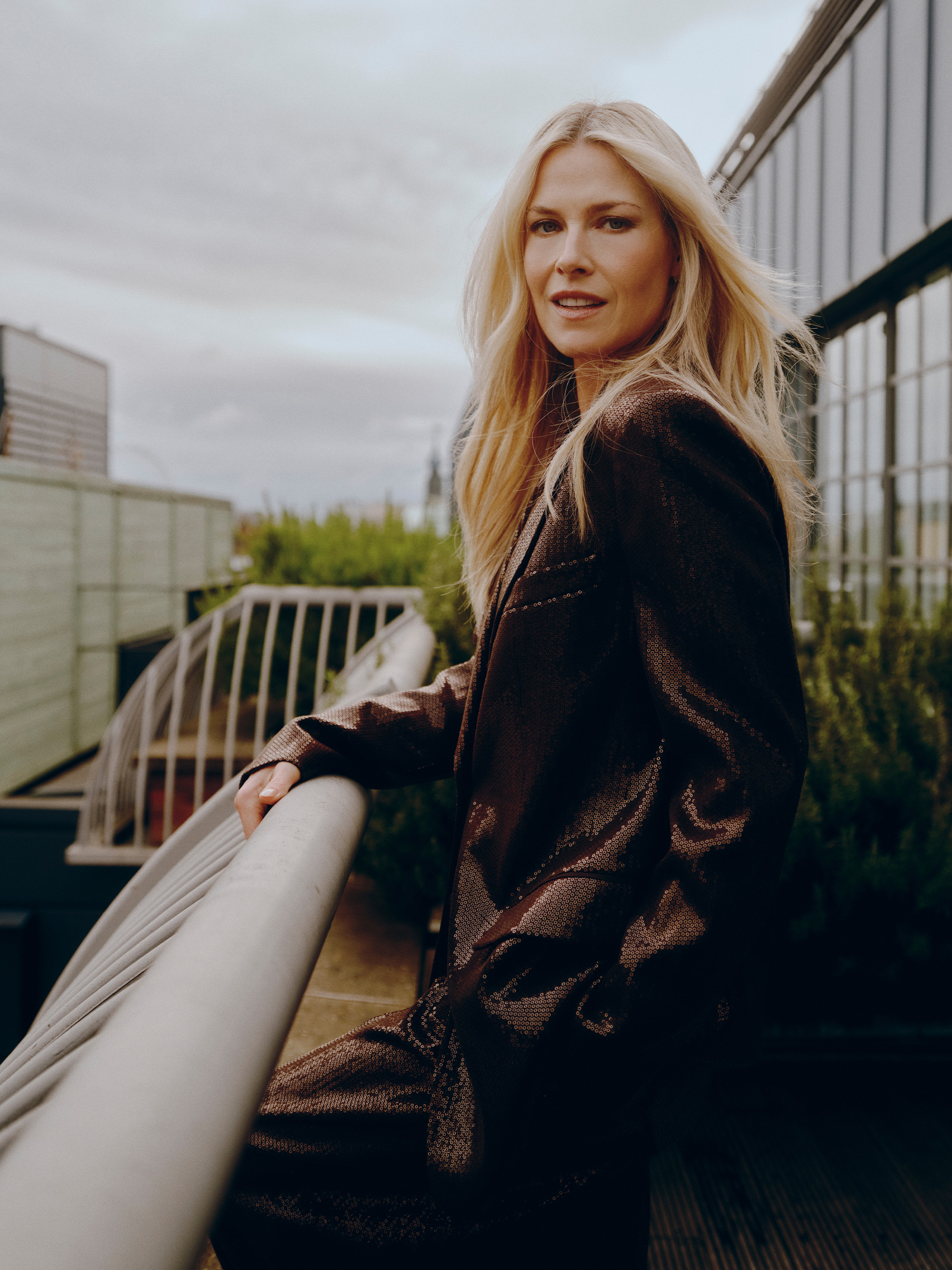 Ali Larter poses on the balcony of her London hotel wearing a chocolate brown sequin Michael Kors suit.