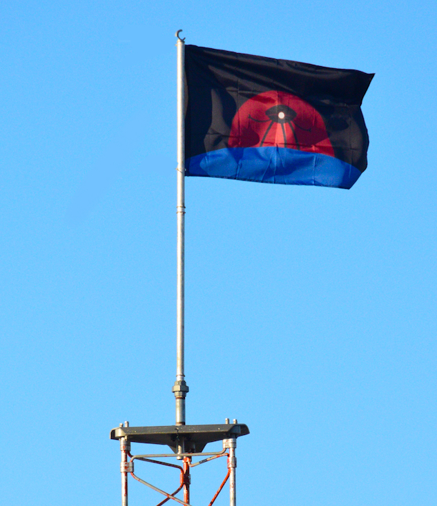 A flag depicting an H.G. Wells-era Martian war machine standing astride Earth with the Angry Red Planet rising behind it.