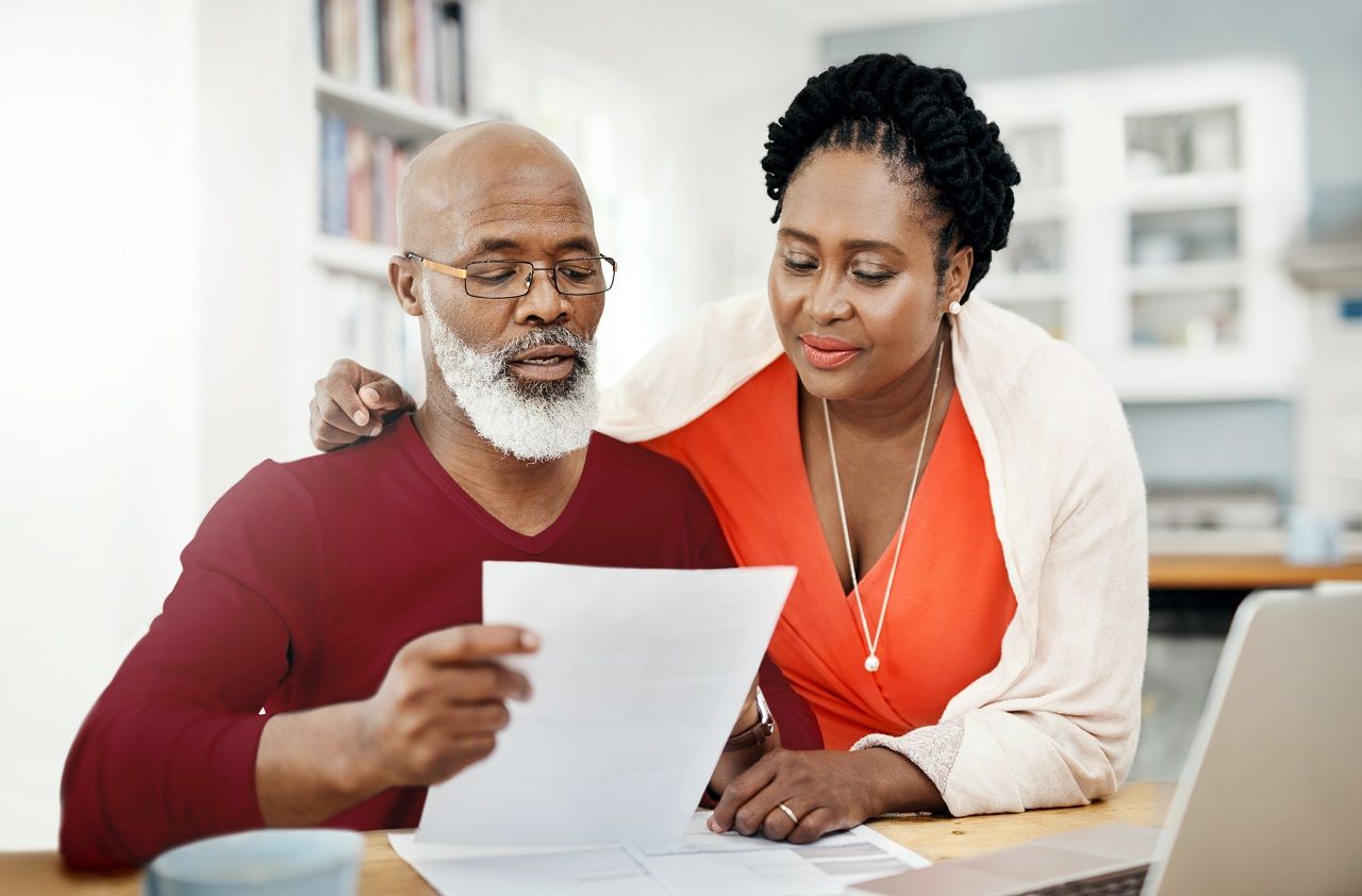 Shot of a mature couple managing their paperwork together at home