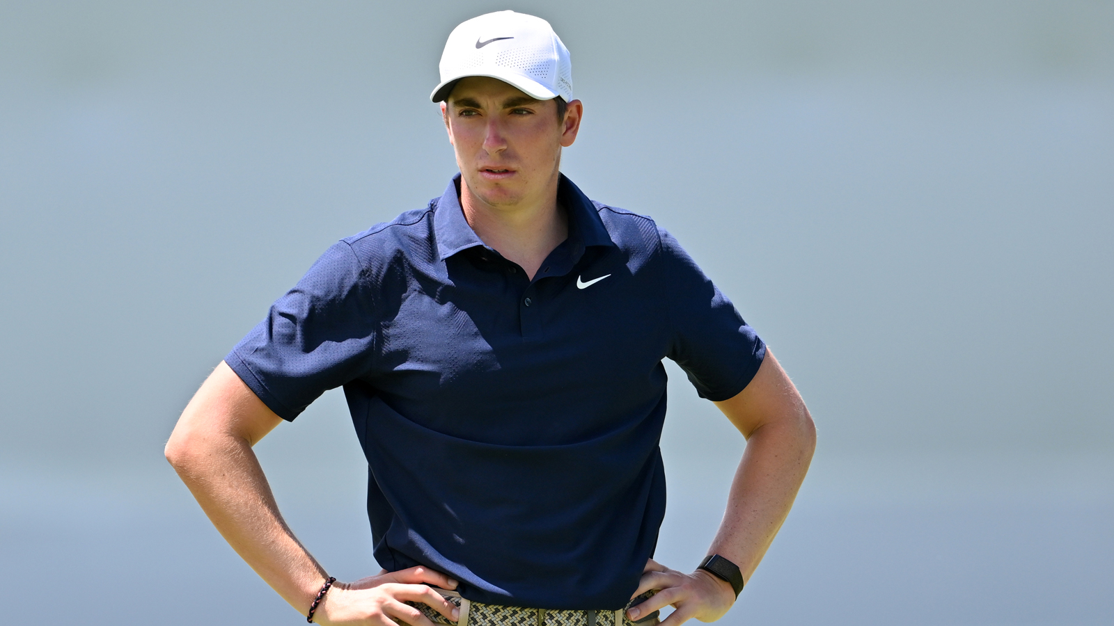 Ben James stands on the green with his hands on his hips