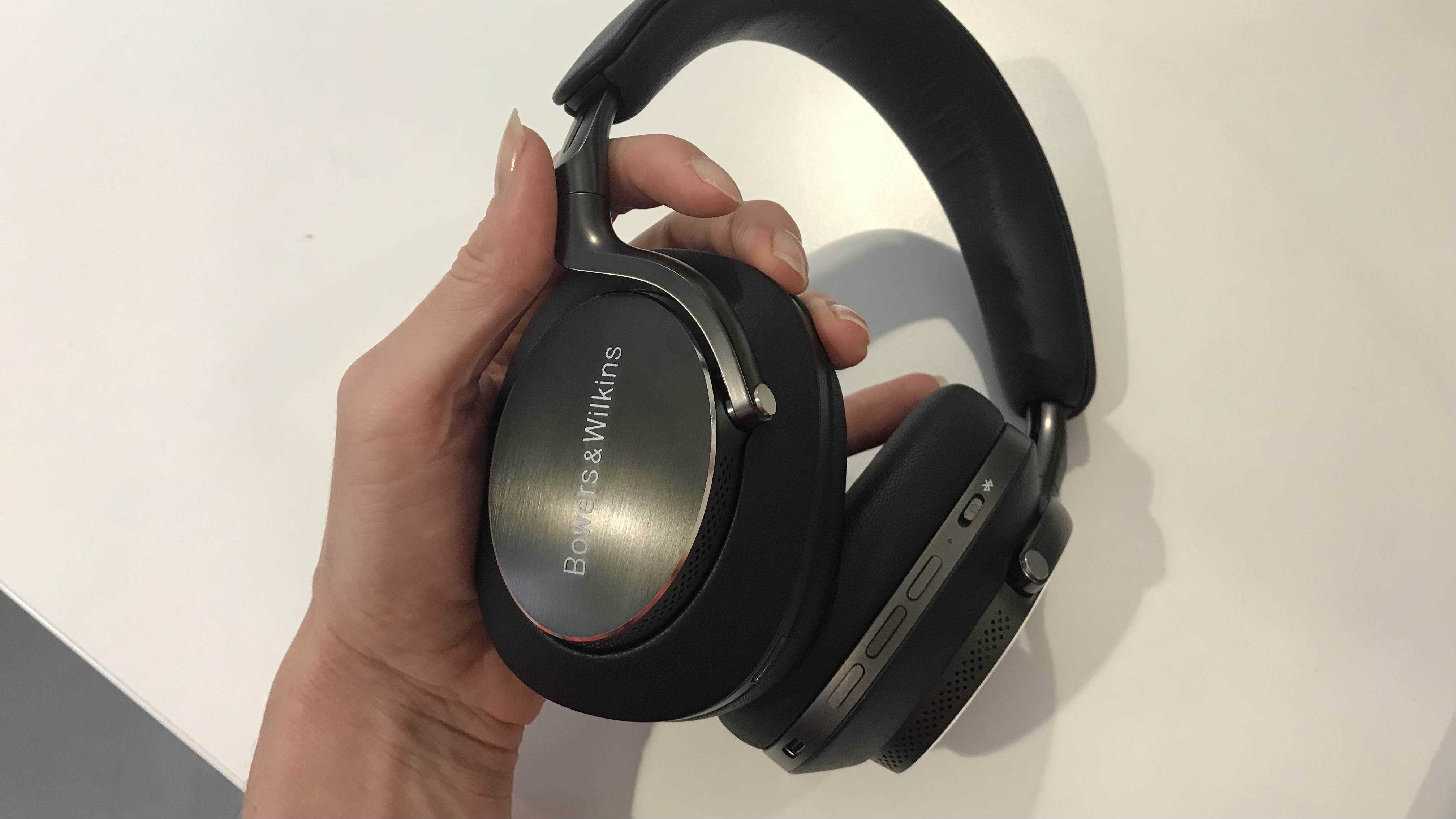 Bowers & Wilkins PX8 over-ears in hand, on white background