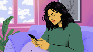 Young woman using a mobile phone while sitting on a purple couch