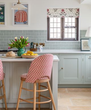 red patterned barstool with wooden legs in sage green country style kitchen