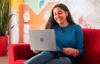 A person smiling with an HP laptop on their lap