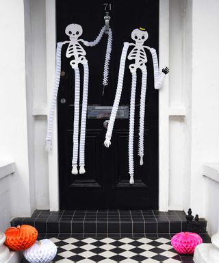 hanging paper skeletons on front door