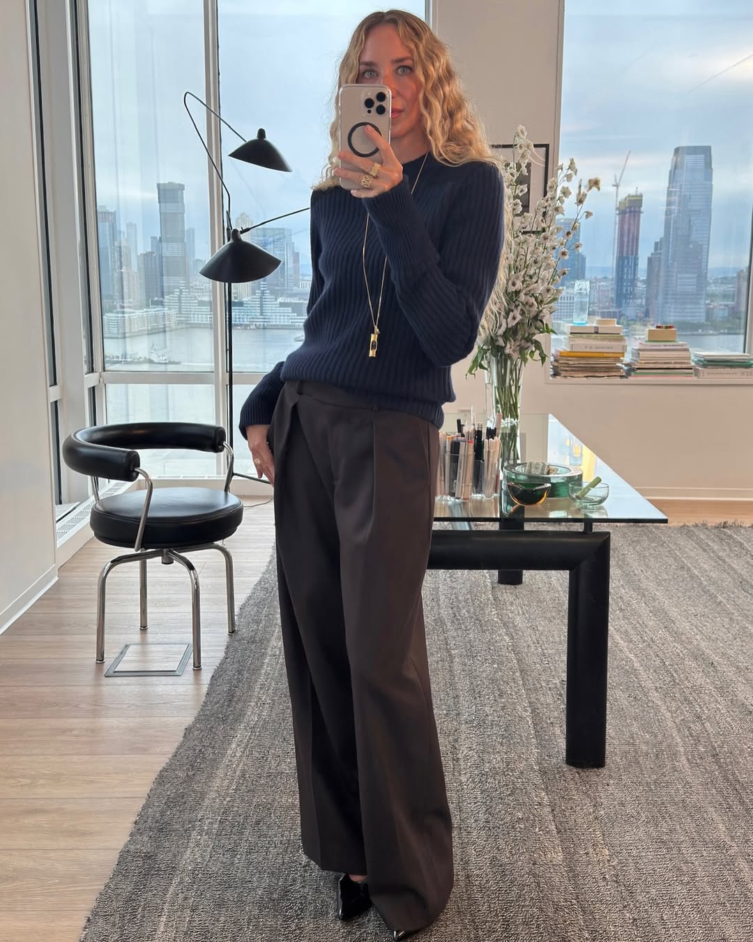 Olympia Gayot takes a mirror selfie wearing a blue cashmere jumper and brown trousers