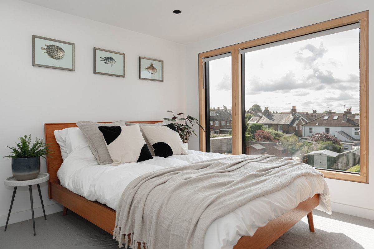 A bedroom in a loft conversion with a large window