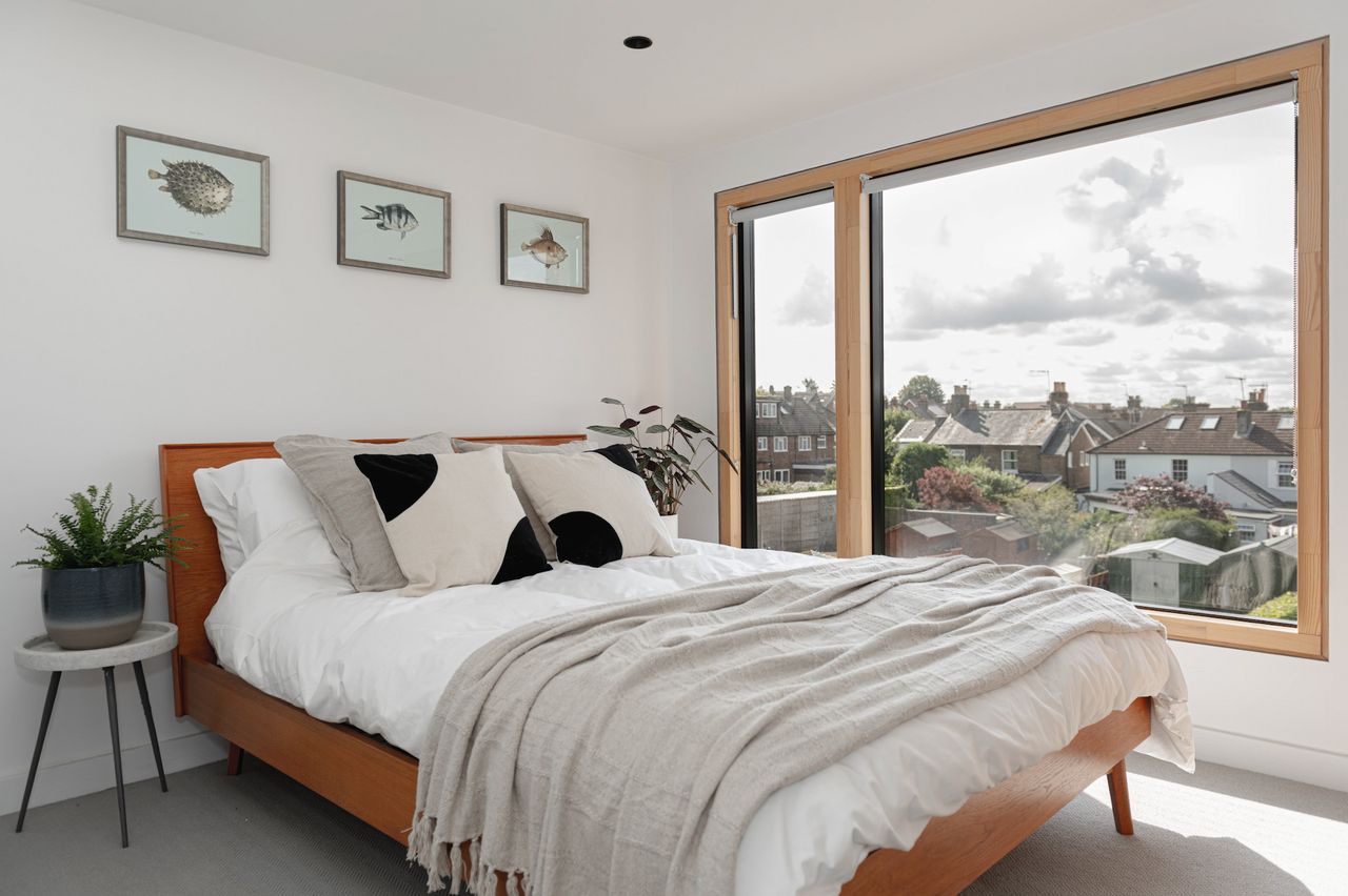 A bedroom in a loft conversion with a large window