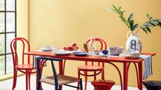 habitat red dining table and chairs with table styling and vase with foliage