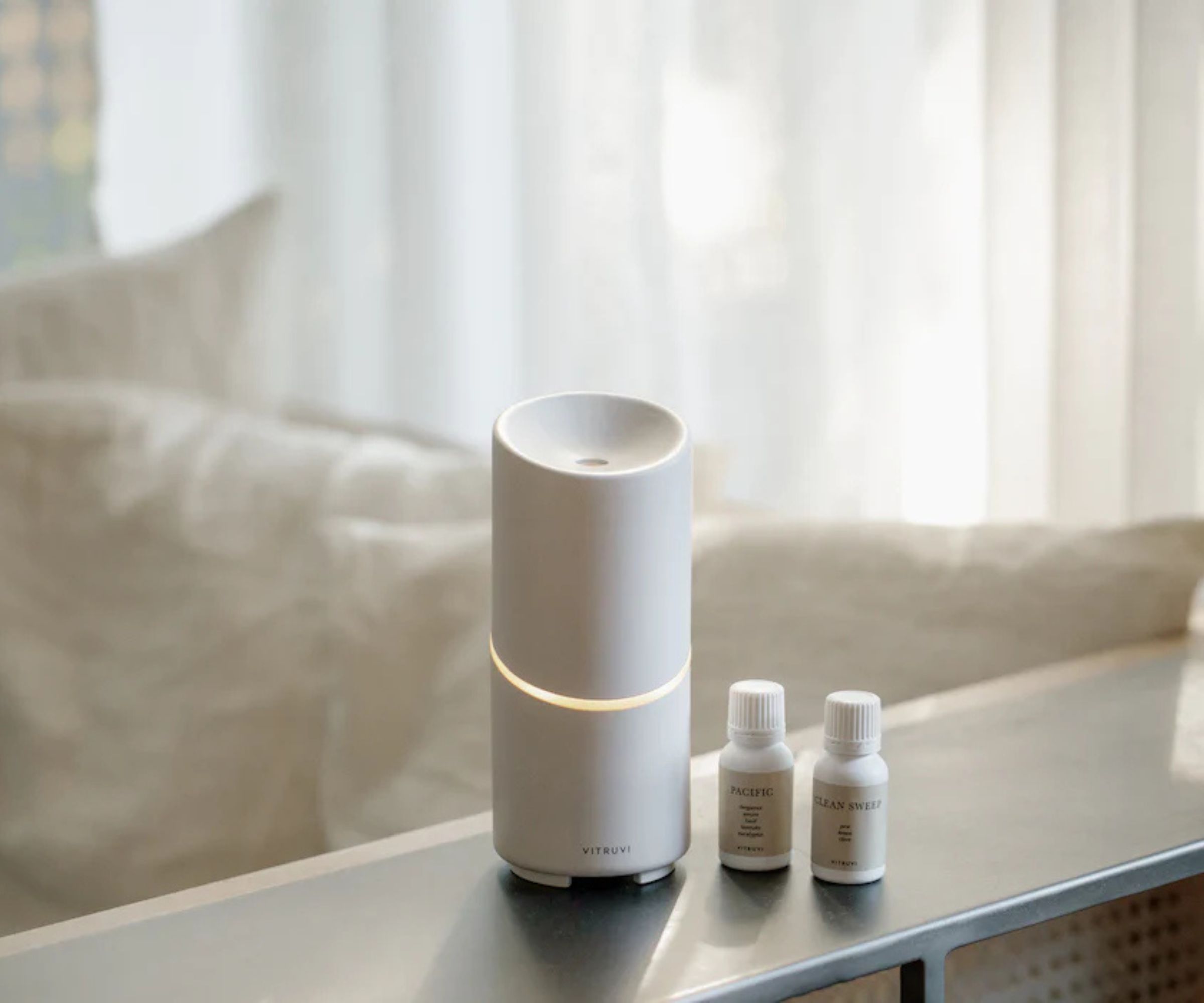 Vitruvi essential oil diffuser on a shelf against a beige background.