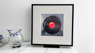 Samsung Music Frame on a table beside a vase